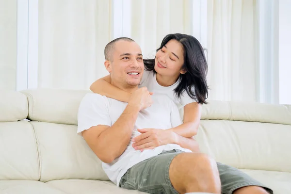 Young Woman Embrace Her Husband While Sitting Couch Living Room — Stockfoto