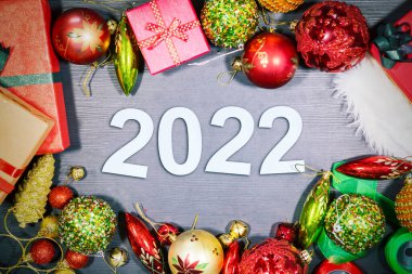 Mutlu yıllar konsepti. Hediye kutularının ve üzerinde 2022 numara olan Noel süslerinin en üst görüntüsü.