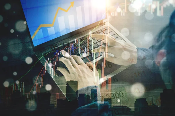 Double exposure of hacker hands using a computer laptop to steal stock exchange data information with finance graph background