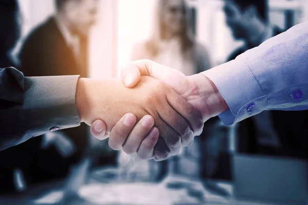 ビジネス関係者の協力を得て会議室に立ちながら握手を交わす二人のビジネスマンの二重露出背景 — ストック写真