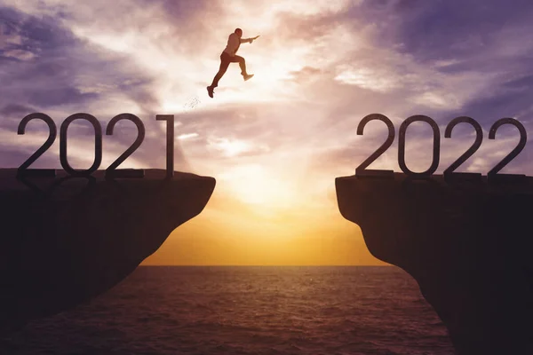 Joven Hombre Negocios Saltando Brecha Acantilado Con Números 2021 2022 — Foto de Stock