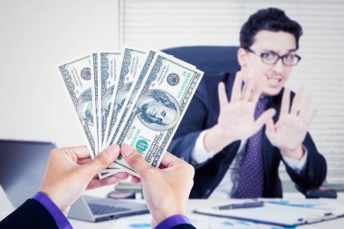 Rüşvet konseptini reddediyorum. Genç işadamı ofiste otururken rüşvet vermeyi reddediyor.