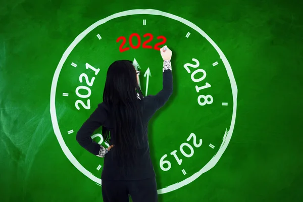 컨셉은 관리자가 시계를 그리는 칠판에 2022 숫자를 뷰이다 사무실에서 — 스톡 사진