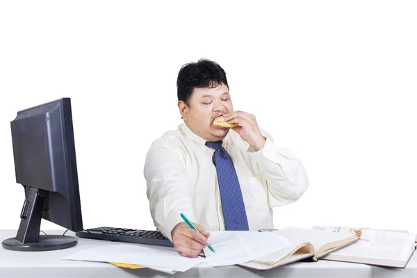 Empresário gordo trabalhando enquanto come 1 — Fotografia de Stock