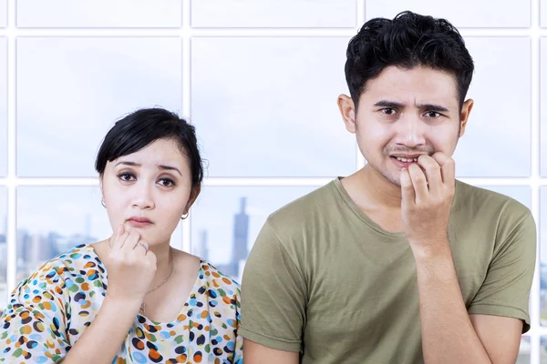 Asustada pareja mordiendo clavos en apartamento — Foto de Stock