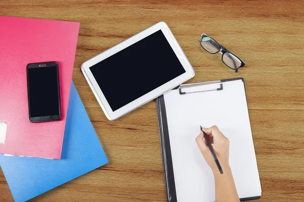 Closeup of hand writes on clipboard — Stock Photo, Image