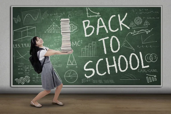 Excited student carrying many books — Stock Photo, Image