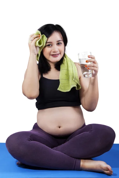 Беременная женщина расслабляется после тренировки — стоковое фото