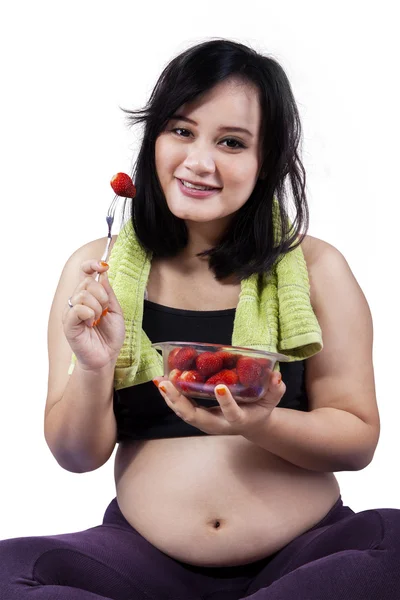 Hübsche schwangere Frau isst Erdbeere — Stockfoto