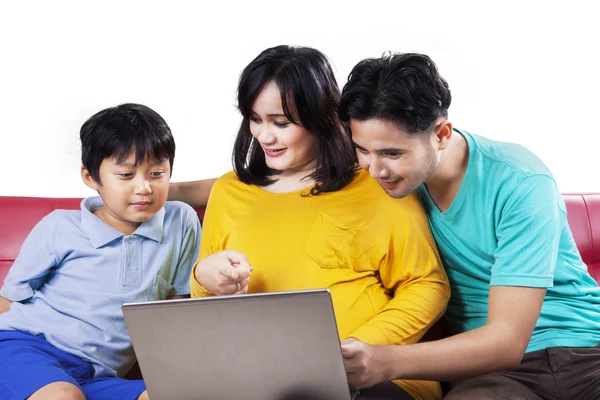 Asiatiska familj sitter på soffan med laptop — Stockfoto