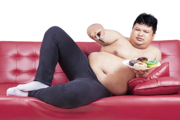 Asiático macho viendo tv y holding donuts — Foto de Stock