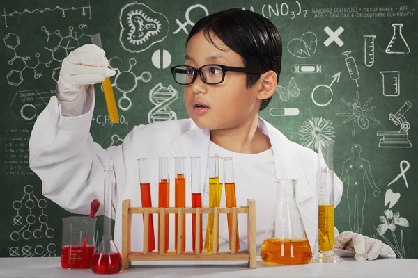 Cientista bonito olhando para fluido químico — Fotografia de Stock