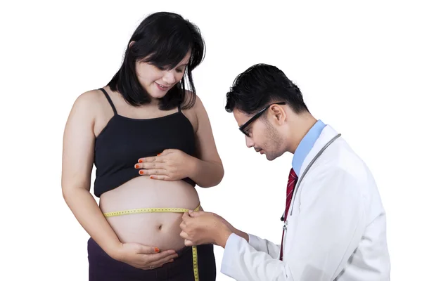 Médico medindo a barriga de uma mulher grávida — Fotografia de Stock