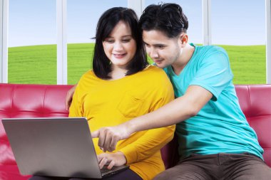 donna incinta e il marito con il portatile