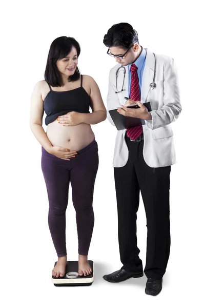 Беременная женщина измеряет свой вес — стоковое фото