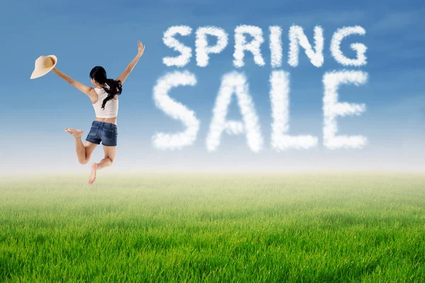 Woman jumps with spring sale cloud — Stock Photo, Image