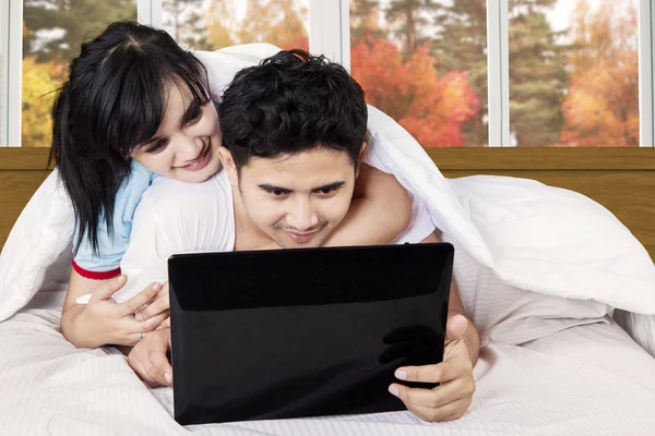 Asian couple using laptop on bed — Stock Photo, Image