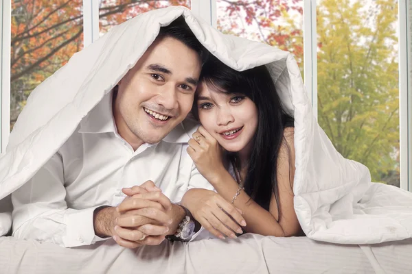 Couple covered blanket in bedroom — Stock Photo, Image