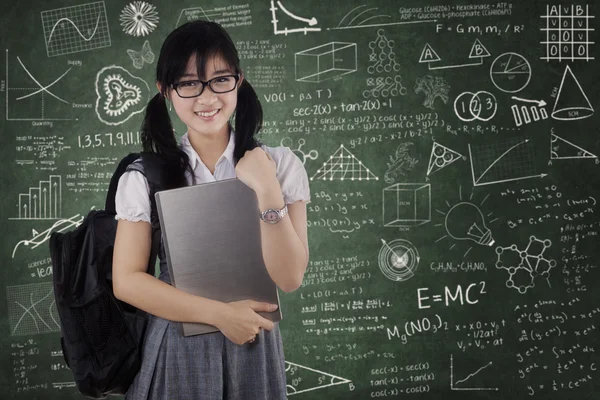 Estudante bonito do sexo feminino segurando laptop na classe — Fotografia de Stock