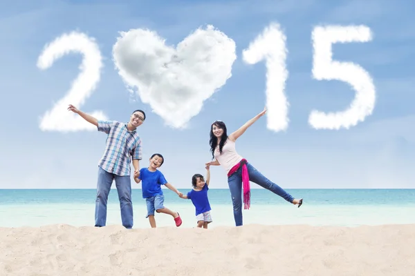 Familie op strand onder wolk van 2015 — Stockfoto