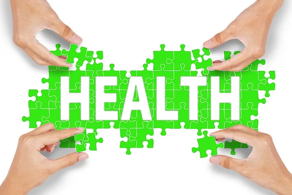 Four hands with health puzzle — Stock Photo, Image