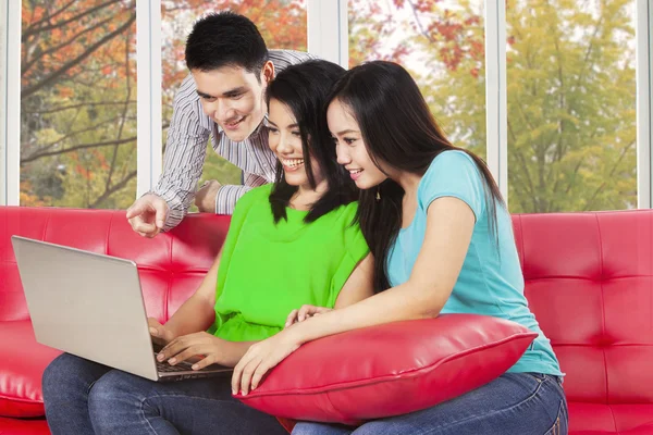 Drie studenten kijken naar laptopcomputer — Stockfoto