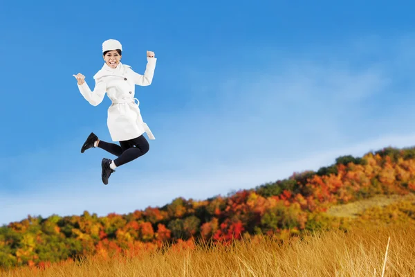 Frau springt mit Herbstjacke — Stockfoto