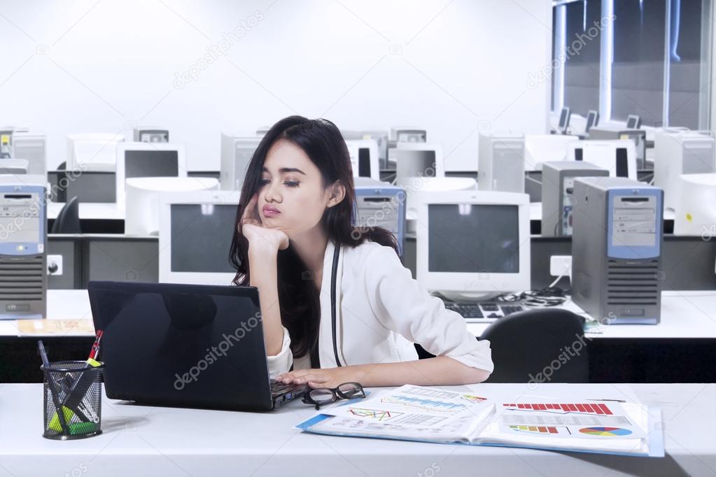 Bored woman working with laptop