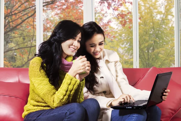 Aantrekkelijk meisje met laptop thuis — Stockfoto