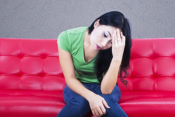 Nahaufnahme einer depressiven Frau auf rotem Sofa — Stockfoto