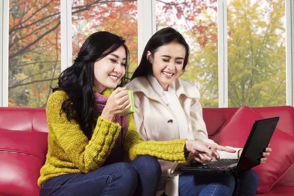 Joyeuses femmes utilisant un ordinateur portable sur le canapé — Photo