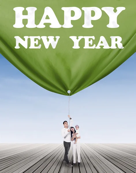 Joyful family pulling a banner new year — Stock Photo, Image