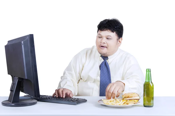 Empresario de obesidad trabajando mientras come — Foto de Stock