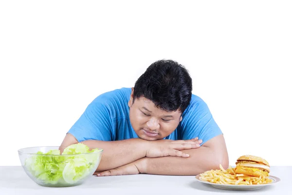 Hombre obeso mirando ensalada — Foto de Stock