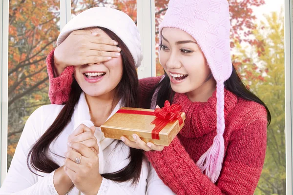 Pretty girl giving present to her friend — Stock Photo, Image