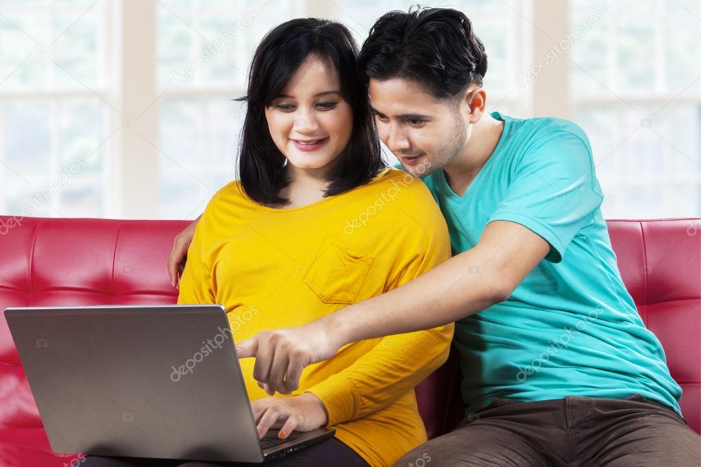 Husband and pregnant woman surfing internet