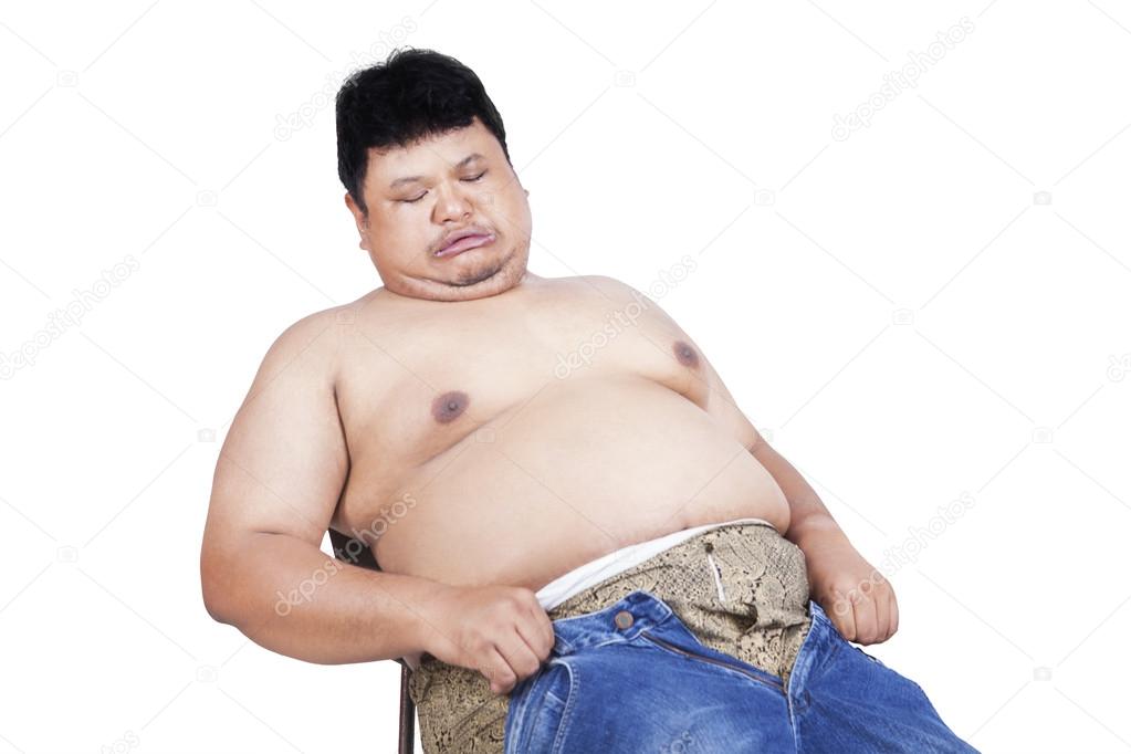 Obese man trying to wear his old jeans