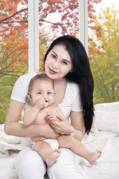 Bebek kız ve annesi kameraya gülümseyen — Stok fotoğraf