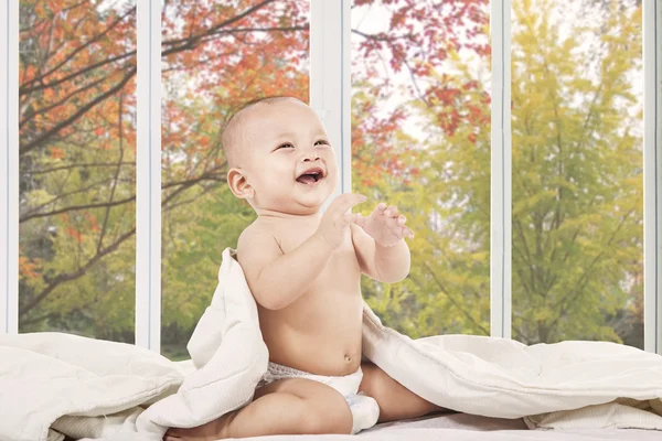 Bebé feliz en el dormitorio riendo solo —  Fotos de Stock