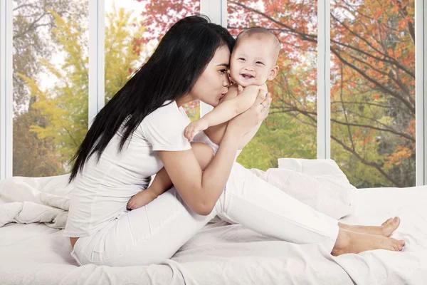 Glimlachende babymeisje met haar moeder — Stockfoto