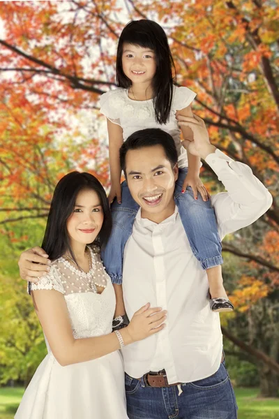 Asian family standing under autumn tree — Stock Photo, Image