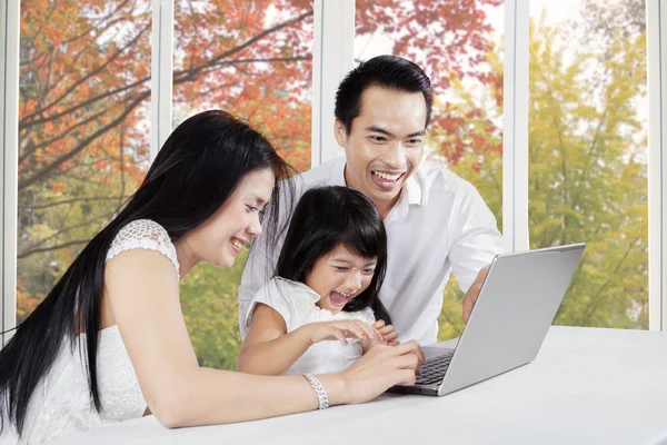 Famille joyeuse avec ordinateur portable à la maison — Photo