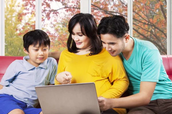 Spansktalande familj med laptop på soffa — Stockfoto