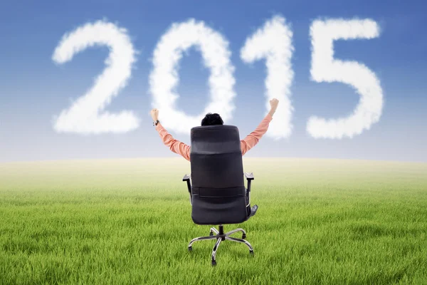 Homme entrepreneur sur chaise avec numéro 2015 — Photo