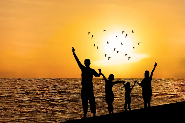 Silhouet van gelukkige familie op strand — Stockfoto