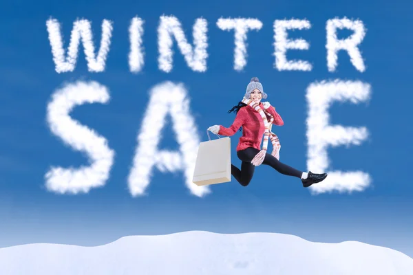 Winter sale clouds and woman jumping — Stock Photo, Image