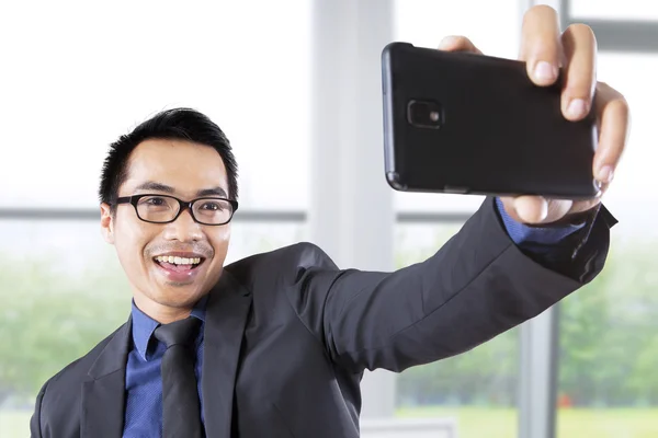 Businessman taking picture in office — Stock Photo, Image