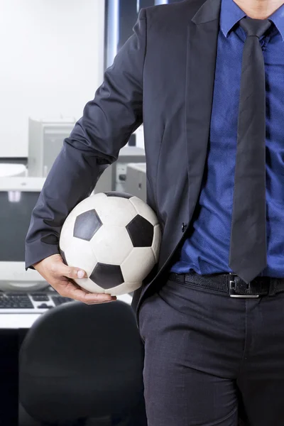 Homme d'affaires tenant le ballon dans le bureau — Photo