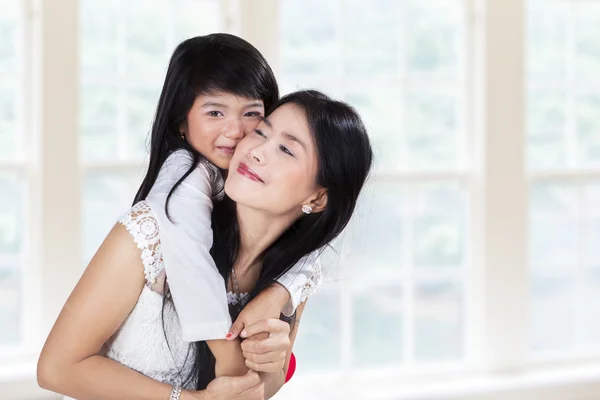 Cute girl embrace mother in home — Stock Photo, Image