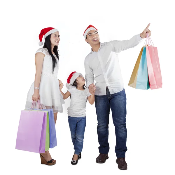 Família com chapéu de santa e sacos de compras — Fotografia de Stock